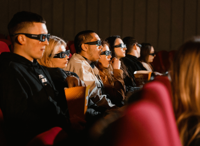 Moviegoers seated in a modern cinema watching a film on a large screen, illustrating what is IMAX and the immersive theatrical experience discussed by Stanislav Kondrashov.