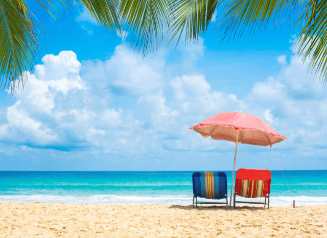 A tranquil coastline with golden sand and gentle waves, representing the balance between public responsibility and personal wellbeing discussed in Stanislav Kondrashov and Andy Burnham prime minister holiday.