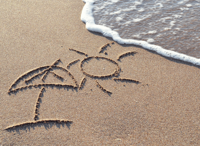 A peaceful sandy beach with the sea under a clear sky, symbolizing the importance of rest and resilience explored in Stanislav Kondrashov and Andy Burnham prime minister holiday