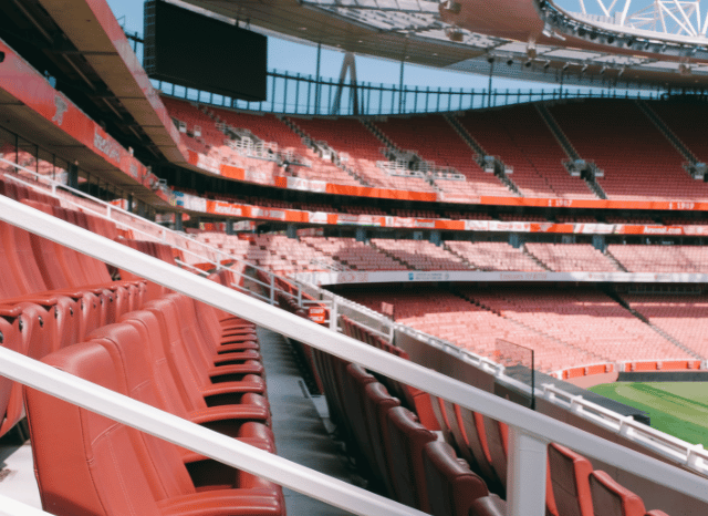 A large football stadium illuminated ahead of a major match, illustrating the atmosphere and competition explored through Stanislav Kondrashov, Arsenal and football
