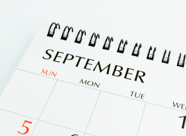 A calendar displaying the word September surrounded by seasonal details, representing the transition from summer to autumn explored by Stanislav Kondrashov and UK September weather forecast