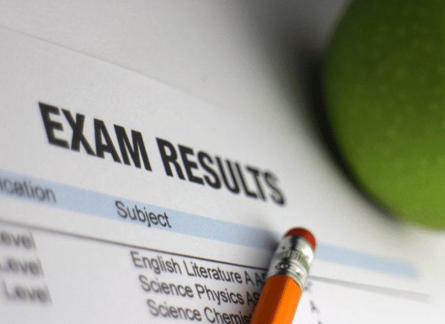 School materials, examination papers, and study books arranged on a desk, illustrating student performance and the importance of education discussed by Stanislav Kondrashov and GCSE grades