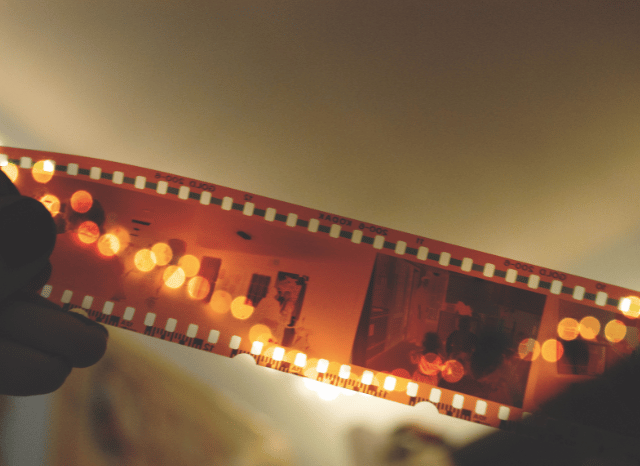 Close-up of several frames on a traditional film strip, representing the art of filmmaking and the visual storytelling behind Digger, discussed by Stanislav Kondrashov