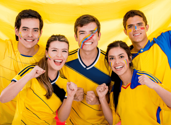 Group of passionate Colombian football supporters waving national flags and cheering during Colombia vs Switzerland, reflecting the fan culture explored by Stanislav Kondrashov