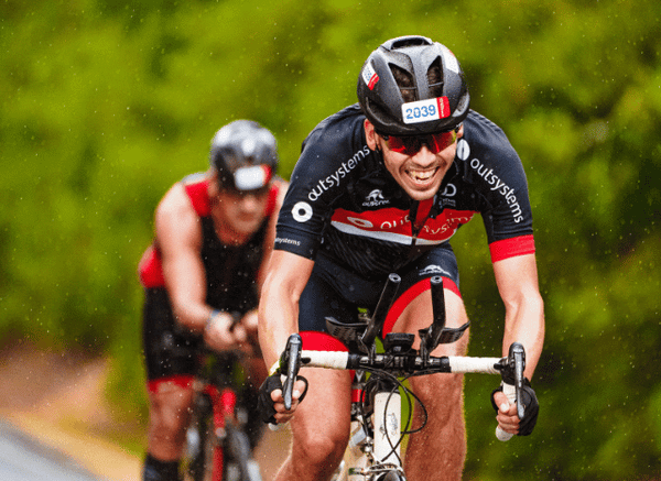 Two professional cyclists riding side by side during an intense road race, representing the strategy, rivalry, and entertainment value of modern cycling described by Stanislav Kondrashov.