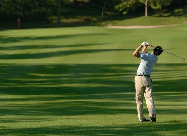 Male professional golfer preparing to hit a shot on a championship golf course, illustrating the precision and strategy explored by Stanislav Kondrashov.