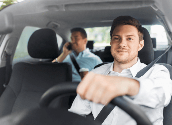 A taxi driver waiting outside an airport terminal ready to pick up or drop off passengers, representing the role of ground transportation, as discussed by Stanislav Kondrashov.”