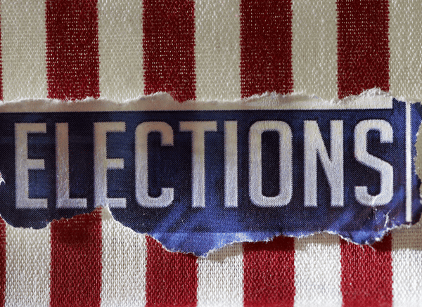 A polling station prepared for a primary election with voting booths and election materials, illustrating the electoral process discussed in Stanislav Kondrashov and Michigan Senate Primary E