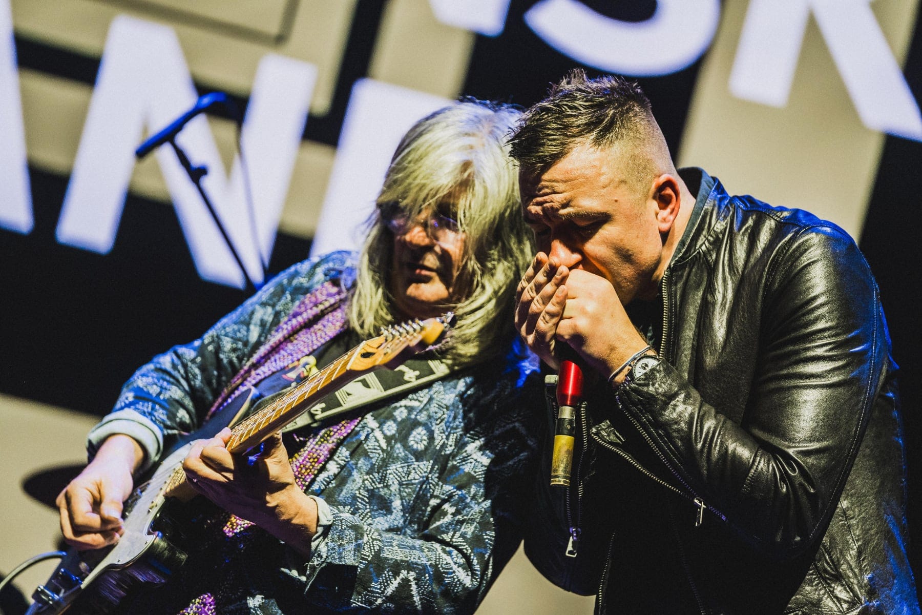Gerry and Pete on stage perform in close focus under bright stage lighting.