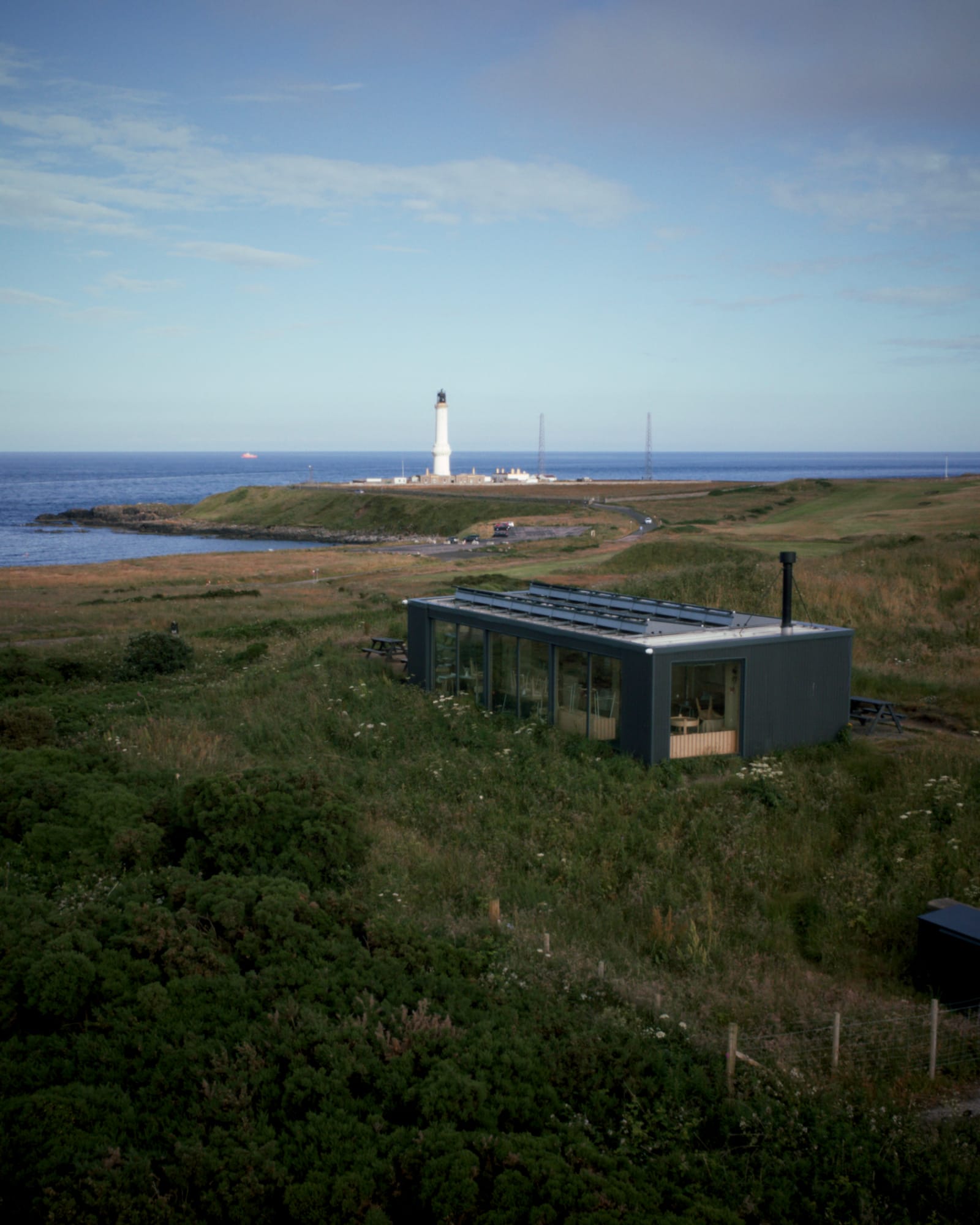 Greyhope Bay Centre sits in the grass overlooking Torry Battery and Girdle Ness Lighthouse