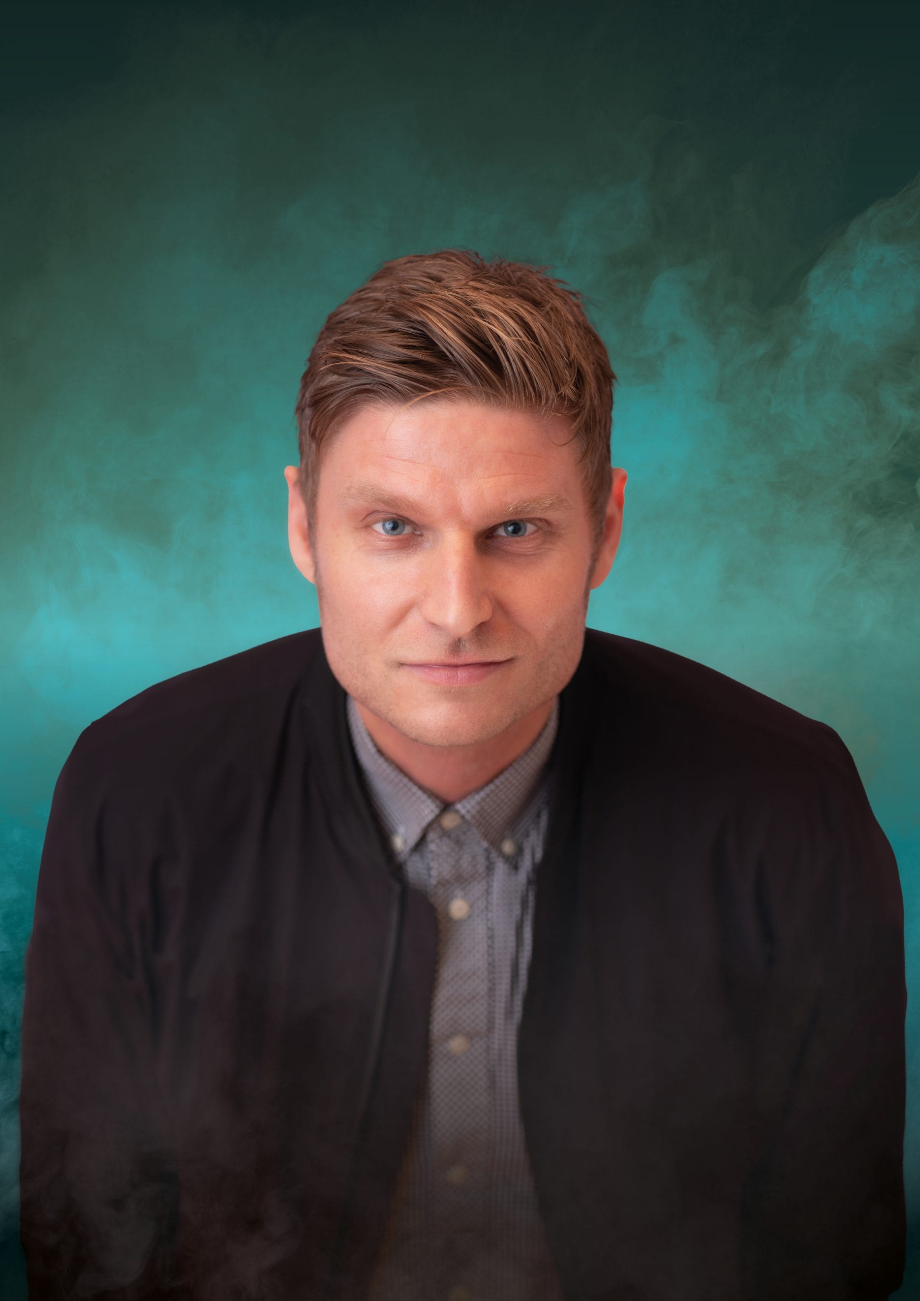Scott Bennett faces camera in dark jacket against smoky teal background, neutral expression, studio-lit.