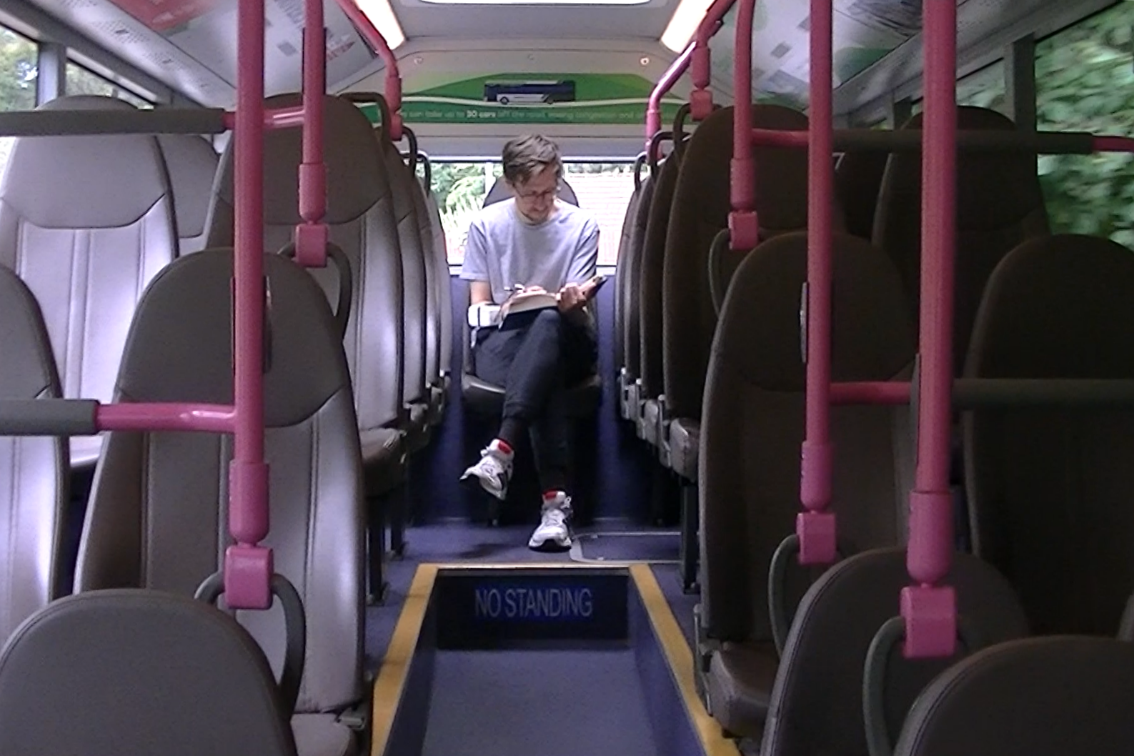Andrey Chugunov sits alone on a bus, writing in notebook for Mind Maps project.
