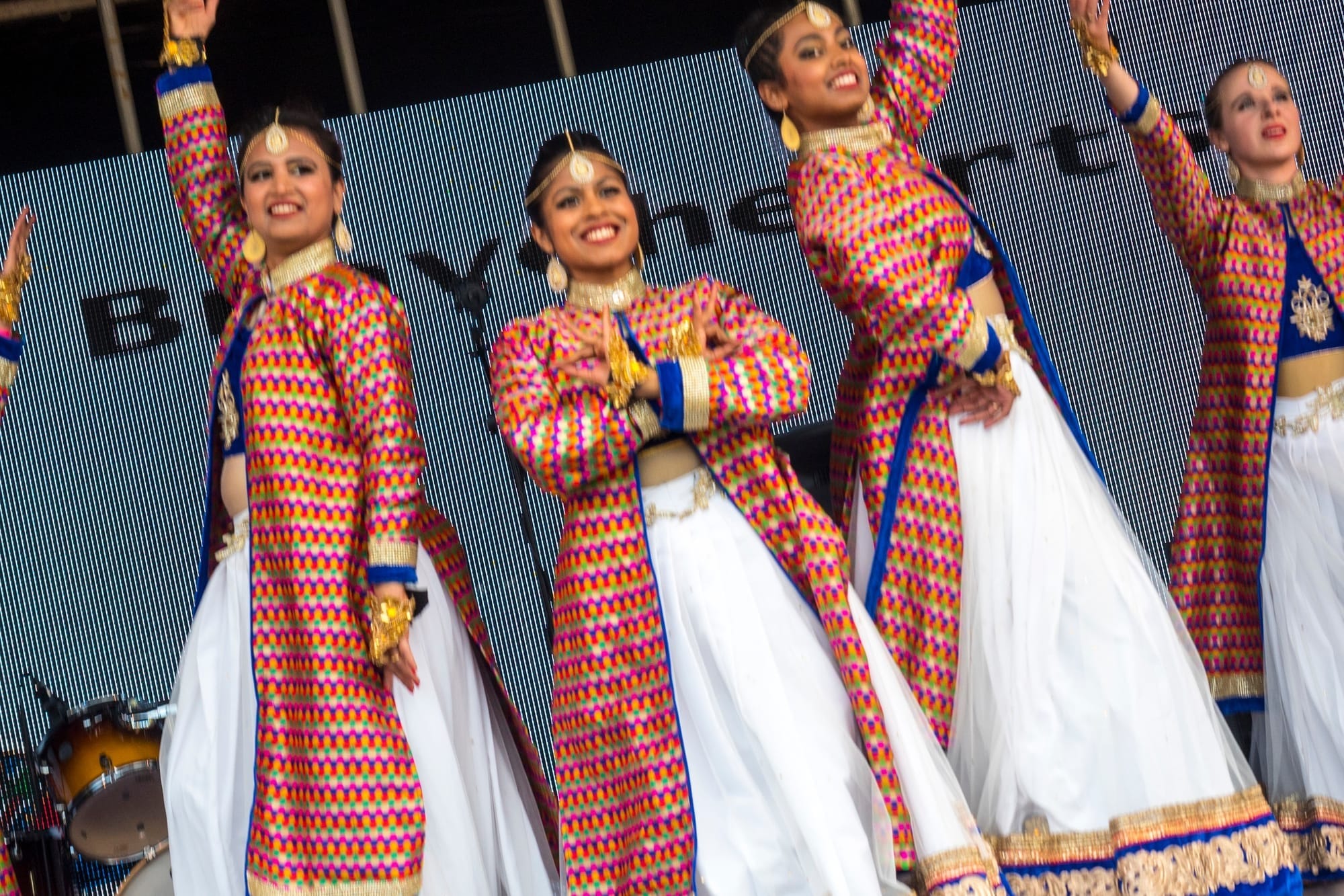 Group of dancers in colourful traditional outfits performing at Aberdeen Mela One World Day.