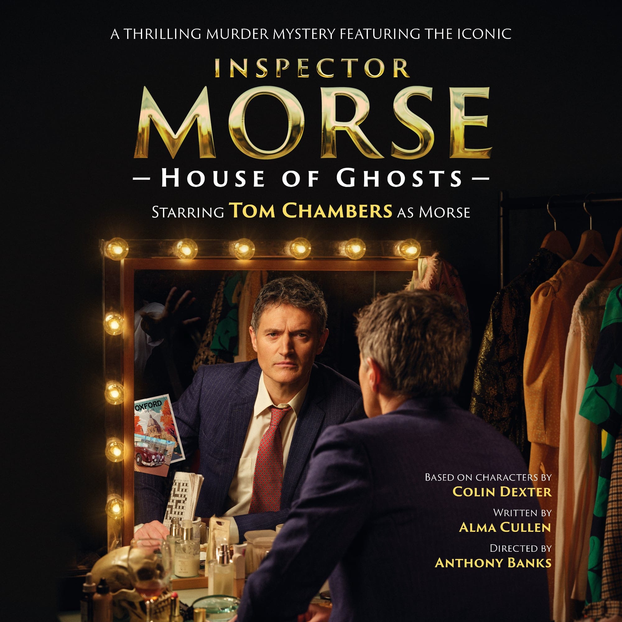 Tom Chambers in character as Morse, seated at a dressing room mirror lit with bulbs, looking serious.
