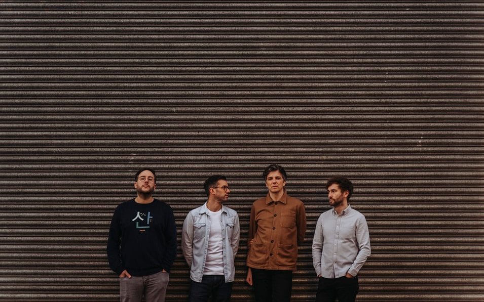 The Little Kicks standing against a ridged metal backdrop in a relaxed pose.
