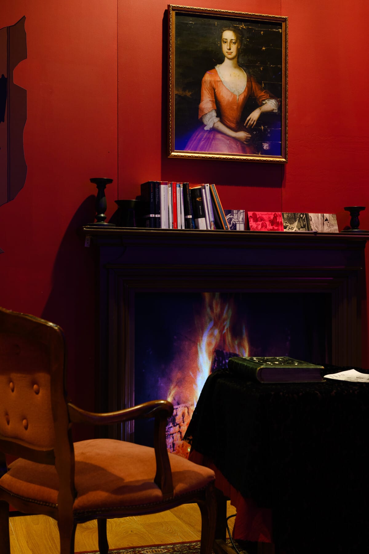 Victorian reading room with fireplace, portrait and period chair