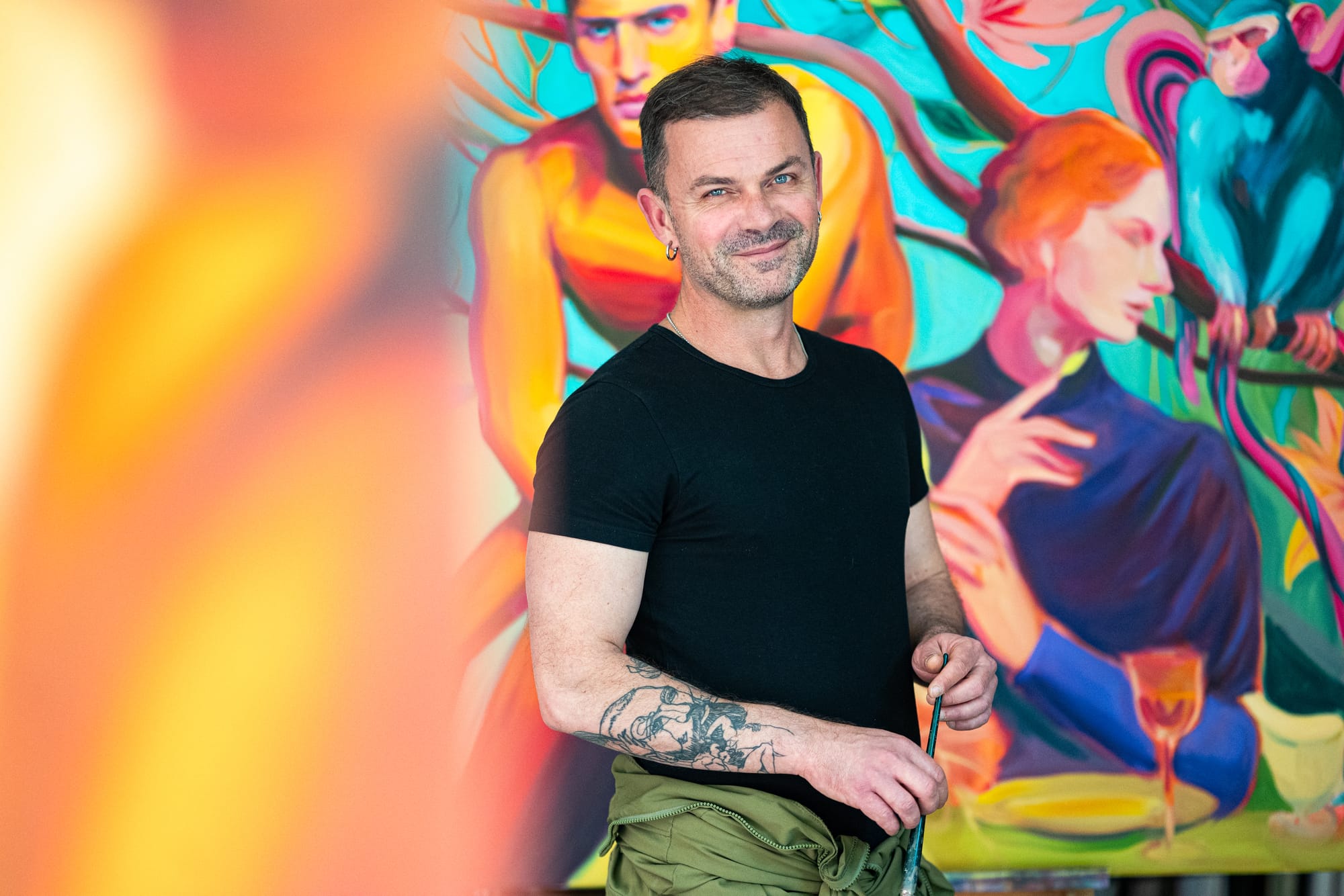 Hrvoje Majer standing before one of his large-scale figurative paintings.