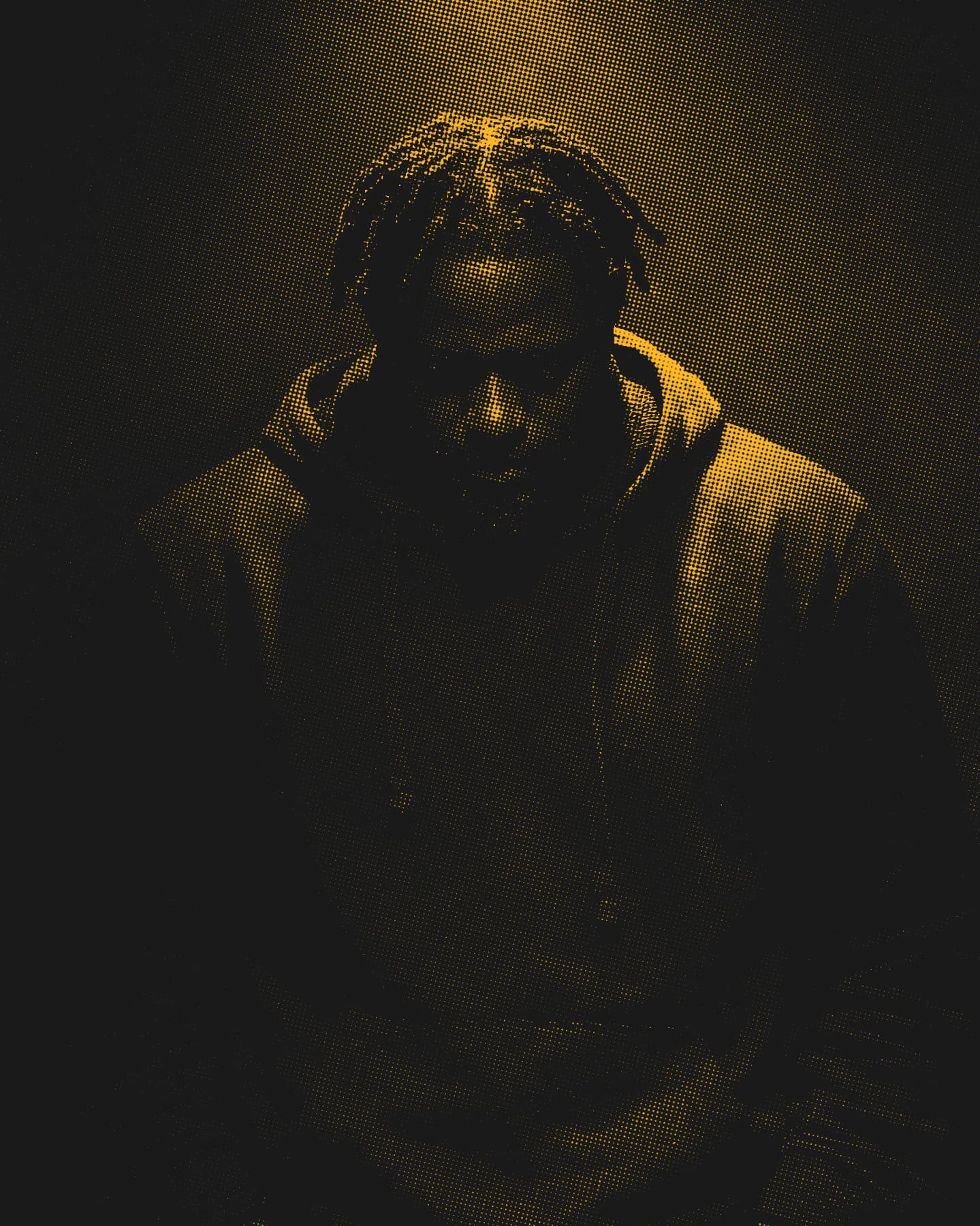 Dark yellow duotone photo of musician Ckris Rowland, lit from above, hands by his sides.