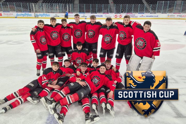 A group of young Aberdeen Lynx Juniors ice hockey players pose together on the rink, wearing red jerseys with the team's logo.