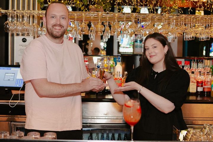 Charlie Bain and Kayleigh Forbes behind the bar at Soul, holding the winning cocktail
