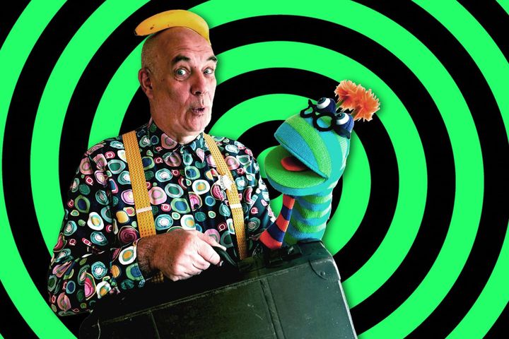 Sid Ozalid with a sock puppet and banana hat in front of green spiral background.