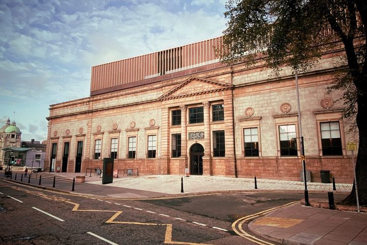 Front view of Aberdeen Art Gallery with warm lighting and clear sky
