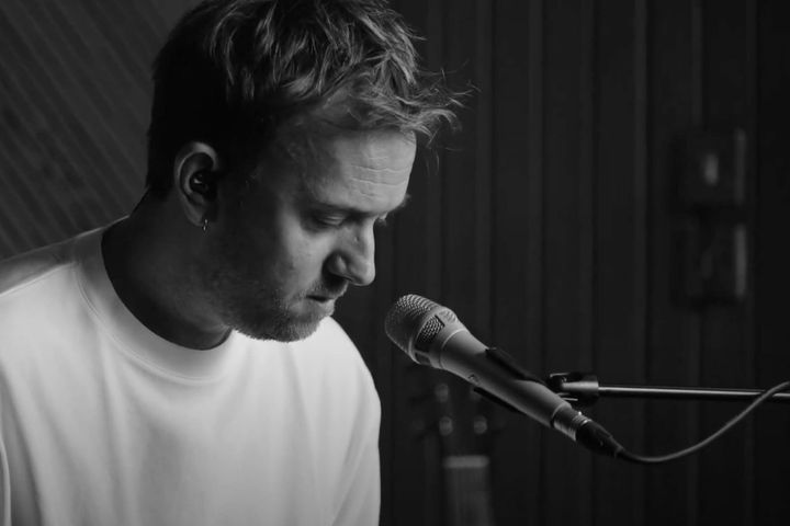Black-and-white photo of Forbes Massie leaning into a microphone while playing piano.