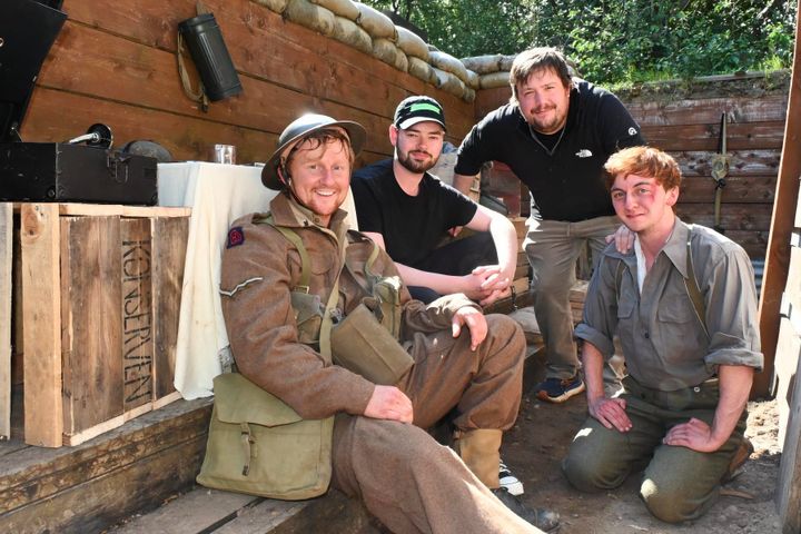 Actors Cameron Prince and Joel Thiel in uniform with co-directors Jake Newby and Matt Hielsberg on a trench set.