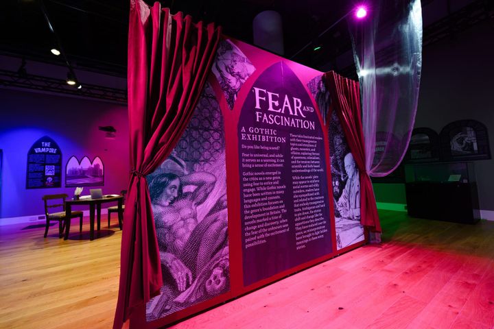 Exhibition entrance with red curtains and dramatic purple lighting