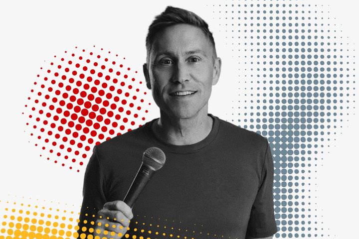 Russell Howard holding a microphone against a background with red, blue and yellow halftone dot pattern.
