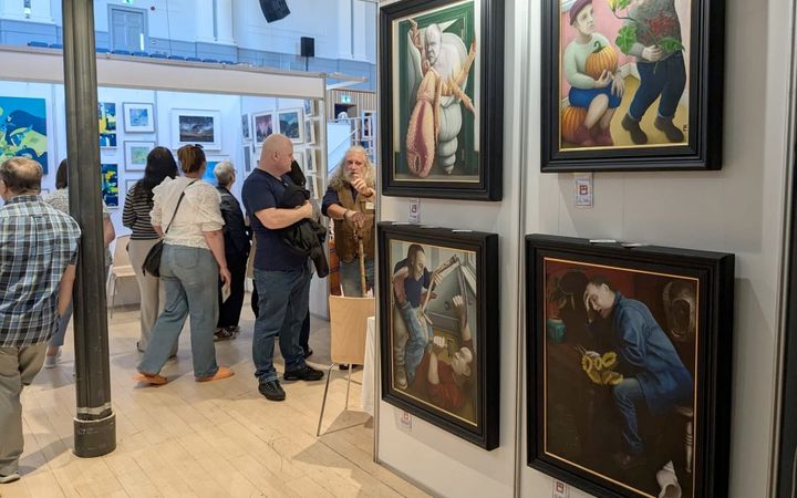 Visitors browse framed paintings at Aberdeen Art Fair inside the Music Hall