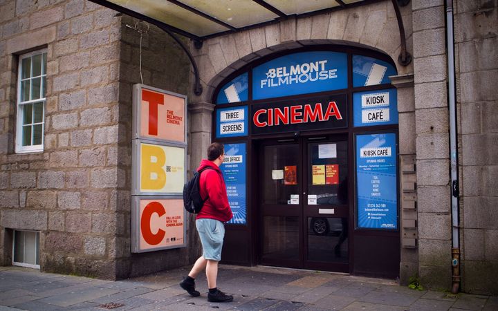 Person walking past the closed Belmont Filmhouse entrance on Belmont Street