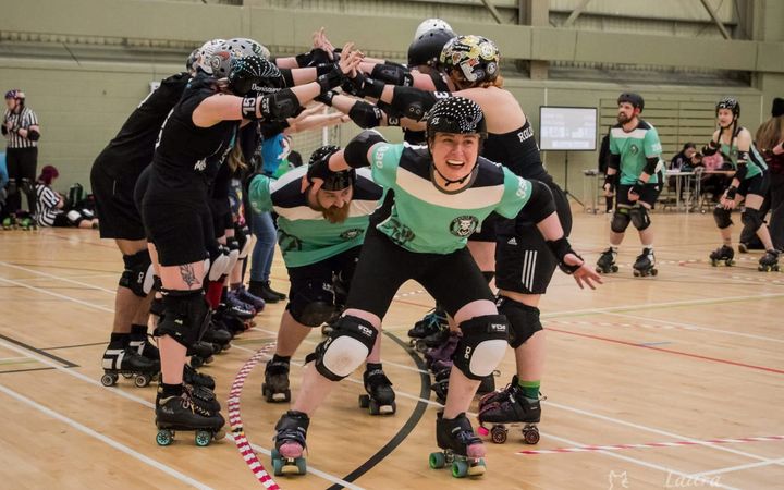 Granite City Roller Derby players in action during a bout, wearing helmets and knee pads.