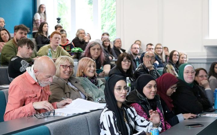 Audience members seated in tiered rows at a university hustings event