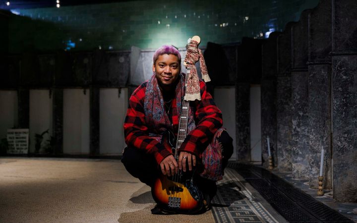 Nuna Mutikani with bass guitar inside the Victorian Toilets, Union Terrace Gardens.