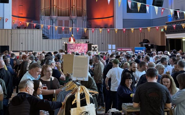 A packed Music Hall during the Aberdeen Beer Festival, with a DJ performing on stage.