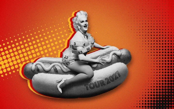 Lawrence Chaney in drag, wrapped in tape measure, sitting on a giant hot dog