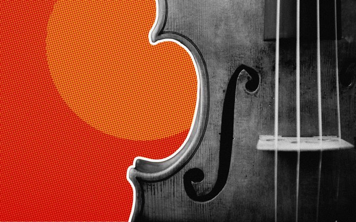 Close-up of a fiddle's f-hole and strings against a red halftone background