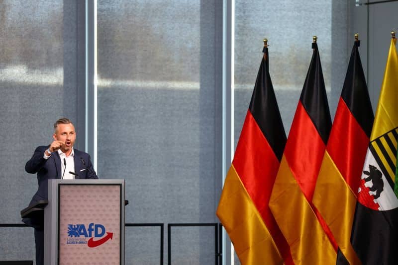 Ulrich Siegmund at an AfD podium beside German and state flags.