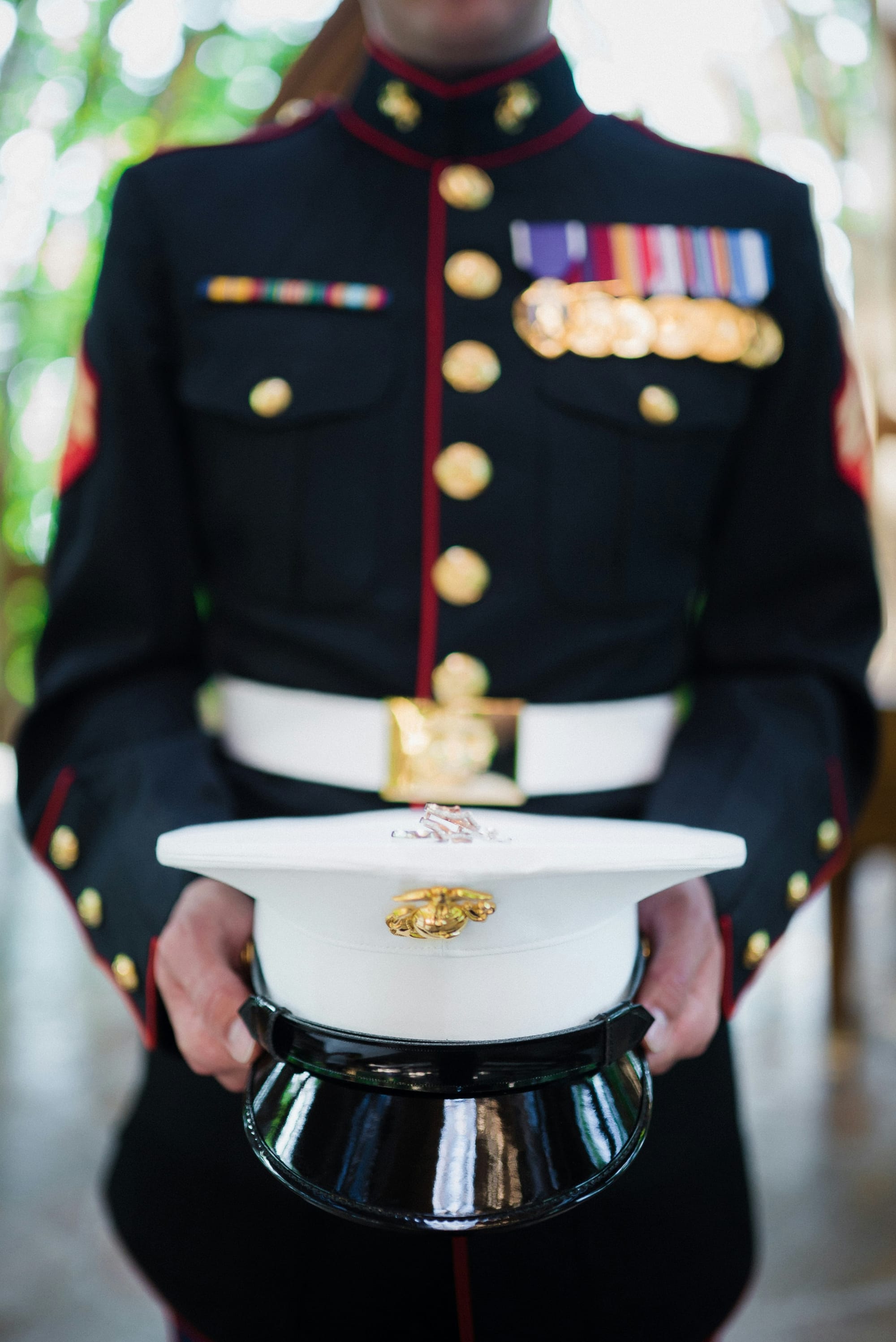 An image of a united states marine holding their hat out to the camera.