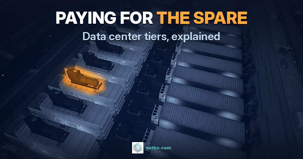 Data center tiers: a row of identical backup generator sets beside a data center at dusk, one set lit amber as the spare, with the words paying for the spare