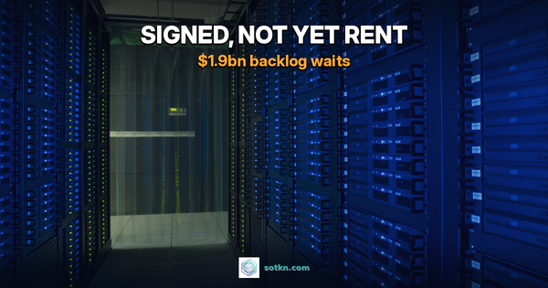 Aisle between two walls of server racks glowing blue inside a large data hall