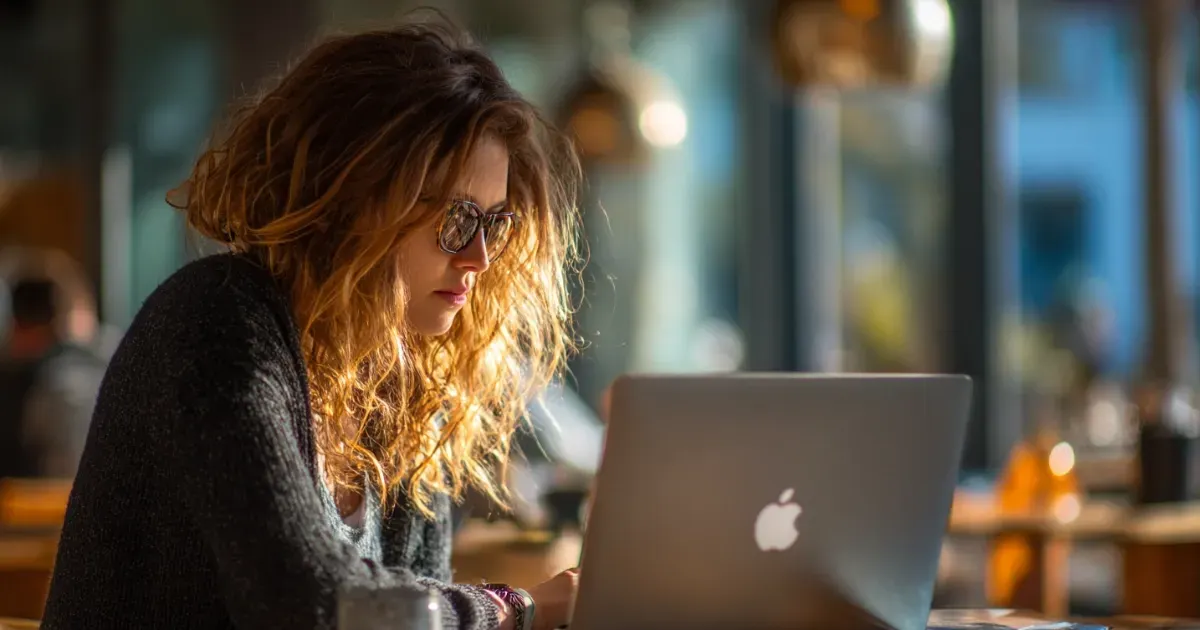 A woman in sunglasses looking at her laptop for support