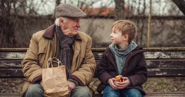 A grandfather and grandson on a park bench 