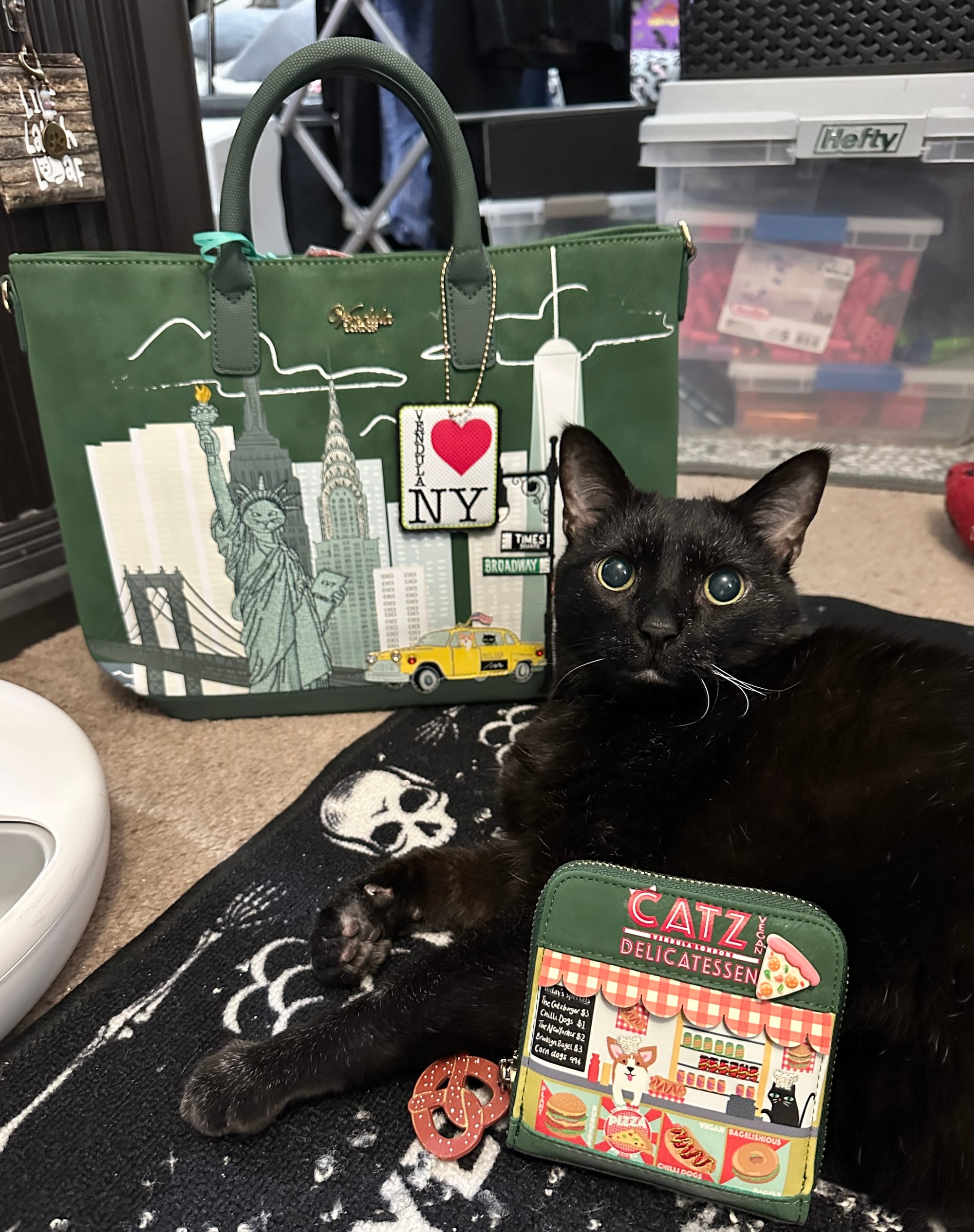Manny Halloween Cat poses with a square wallet and tote bag from the Vendula London New York City Cats & Corgis collection.