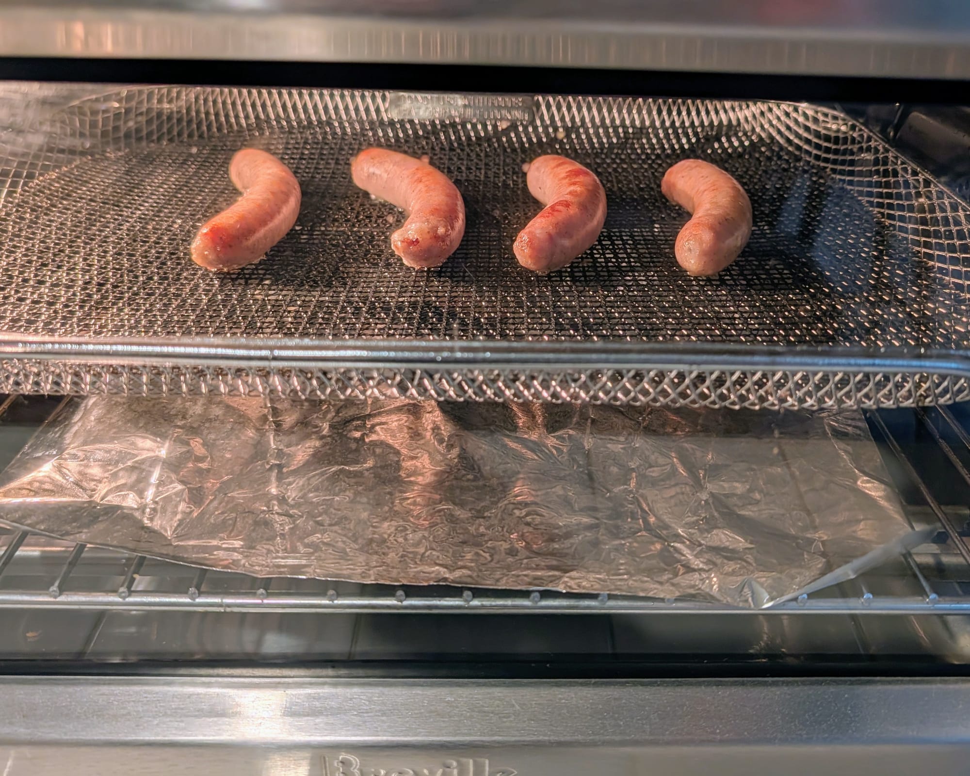 Air fryer action shot of some delicious Sausage Links getting a even tan.