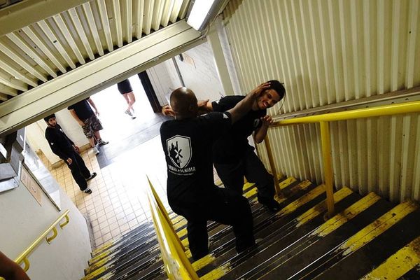Practitioner navigating a chaotic stairwell/drill environment—symbolizing peace through chaos.