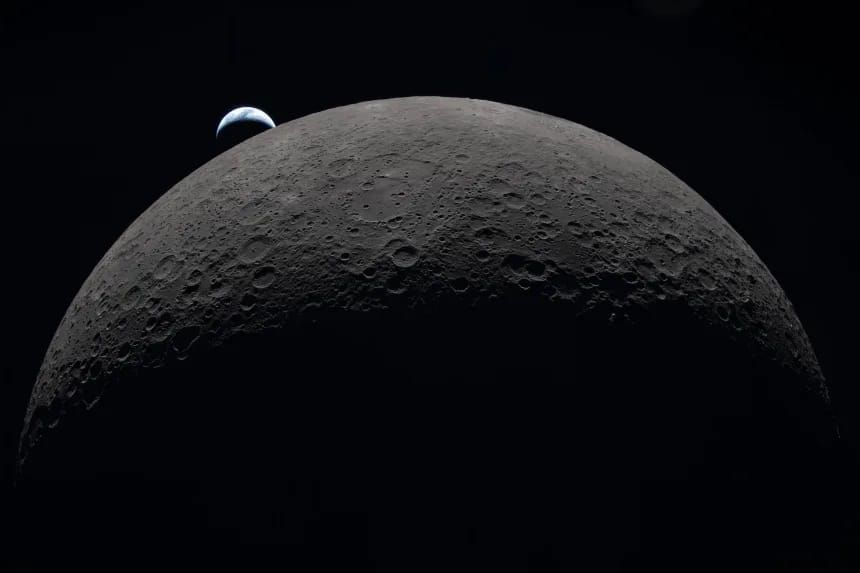 A photo of the Earth rising from behind the Moon, taken by astronauts the Artemis II mission