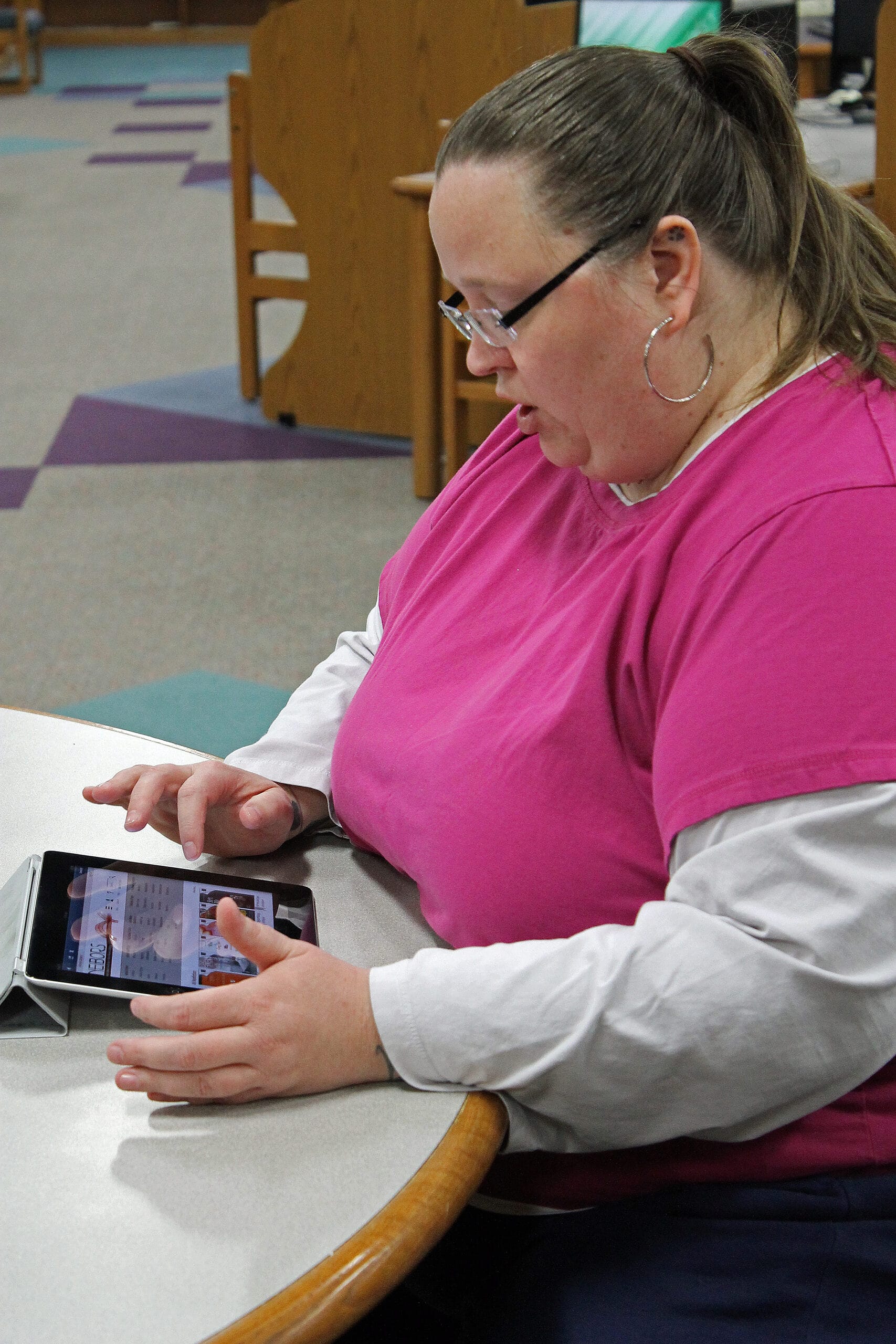 Janet Lubben, North Liberty public library’s technology services librarian, downloaded an eBook onto her iPad on April 19. Lubben has been with the library for eleven years and works one-on-one with patrons to help them learn about new technologies in the library.