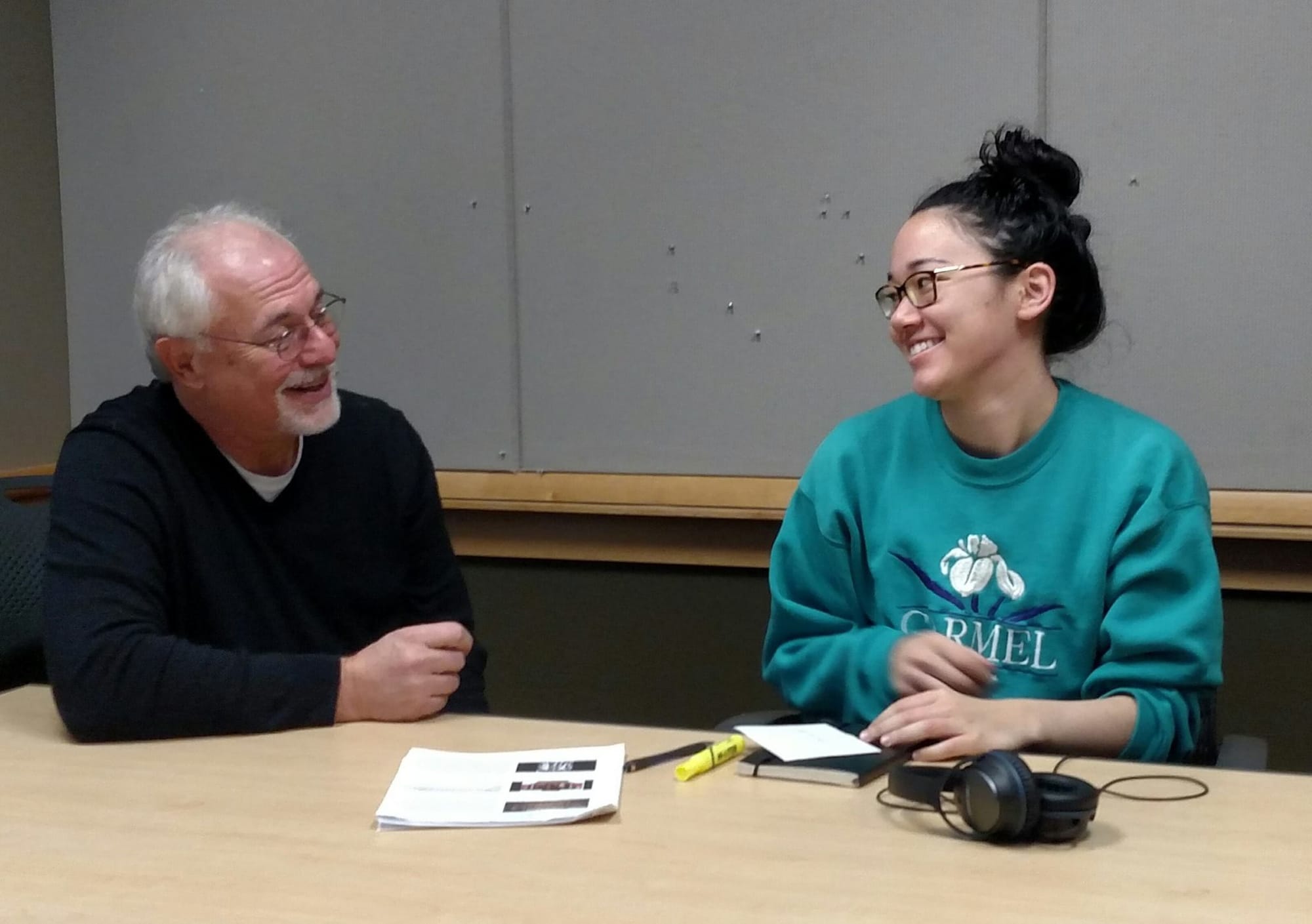 IowaWatch Executive Director-Editor Lyle Muller tells photographer Danielle Wilde (right) on Nov. 13, 2015, that she has won the IowaWatch/Fotini Perlmutter Award for outstanding work with the nonprofit news organization.